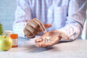man's hand with medicine spilled out of the pill
