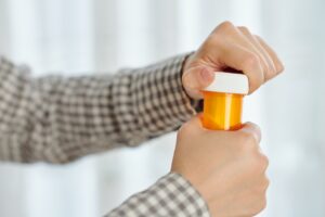opening plastic bottle of tablets